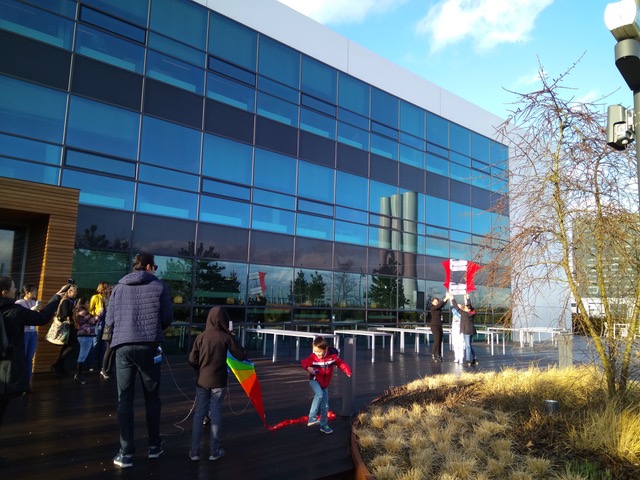 group of adults and children testing 2 kites with environment sensors attached outdoors