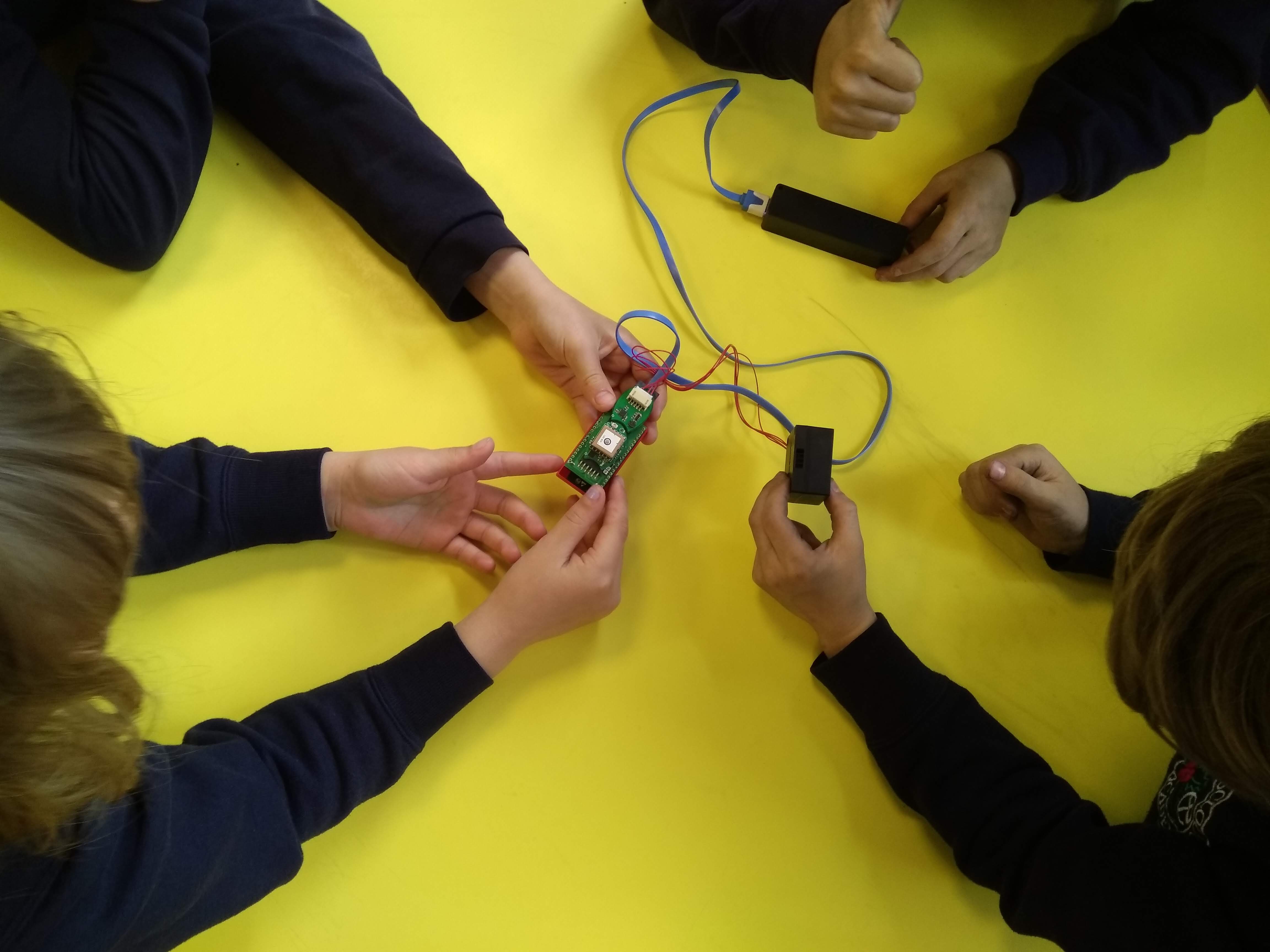 children collaborating around a table with air quality sensor project