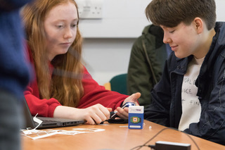 2 girls coding air quality project around a laptop