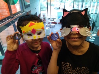 2 young girls wearing animal masks they've created with LEDs