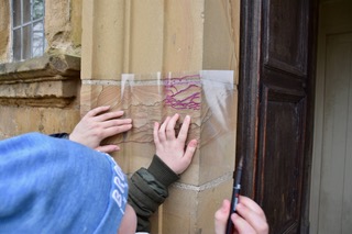 girl tracing contour of a castle wall on an acetate