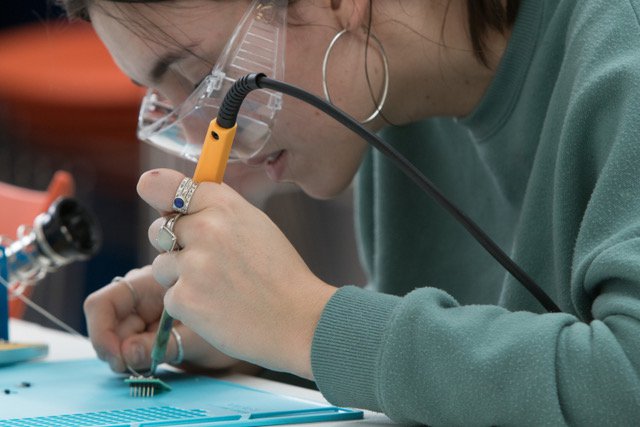 student soldering an iot project